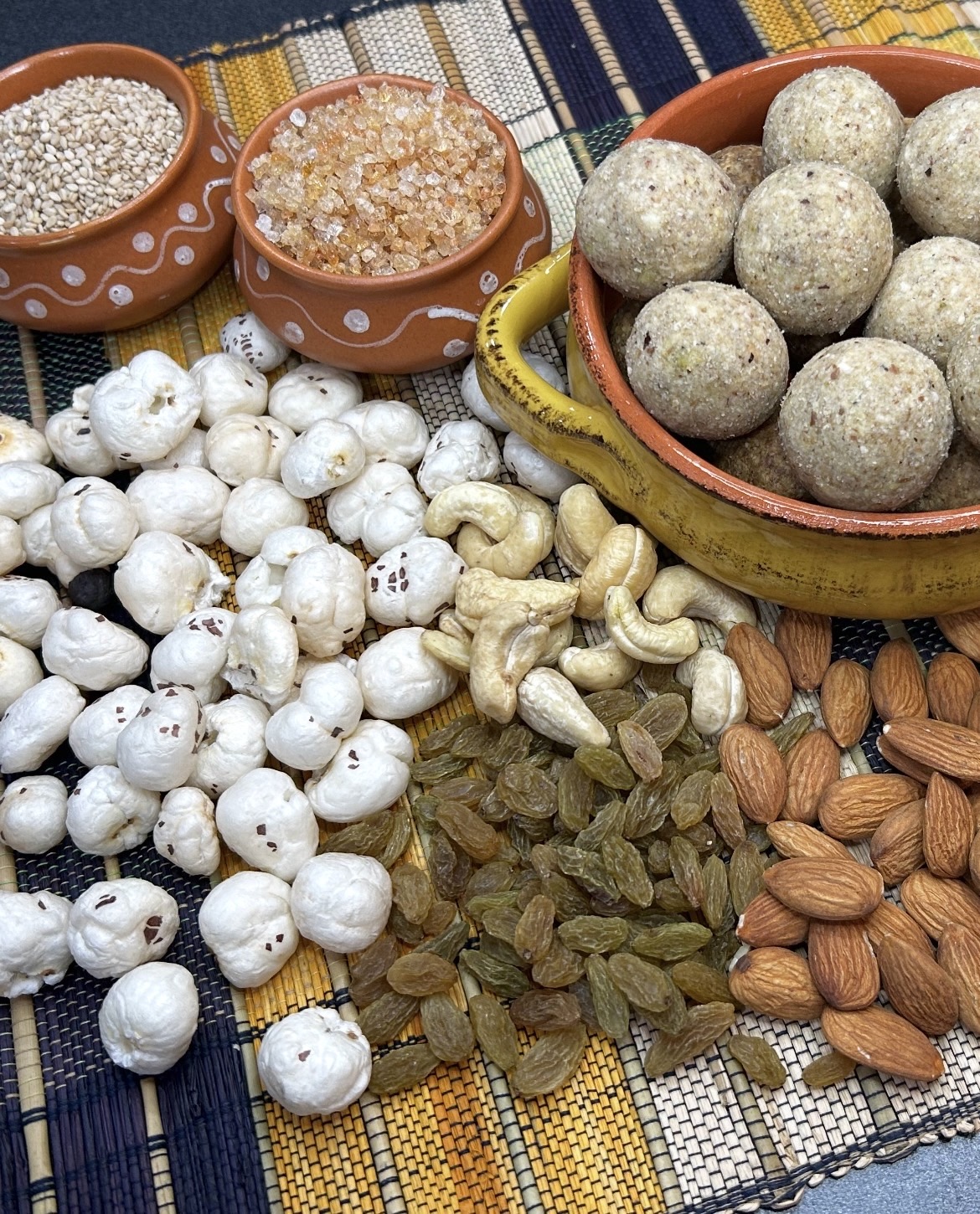 Gond makhana laddoos in a terracotta bowl with makhana, almonds, cashews, raisins, sesame seeds and misri