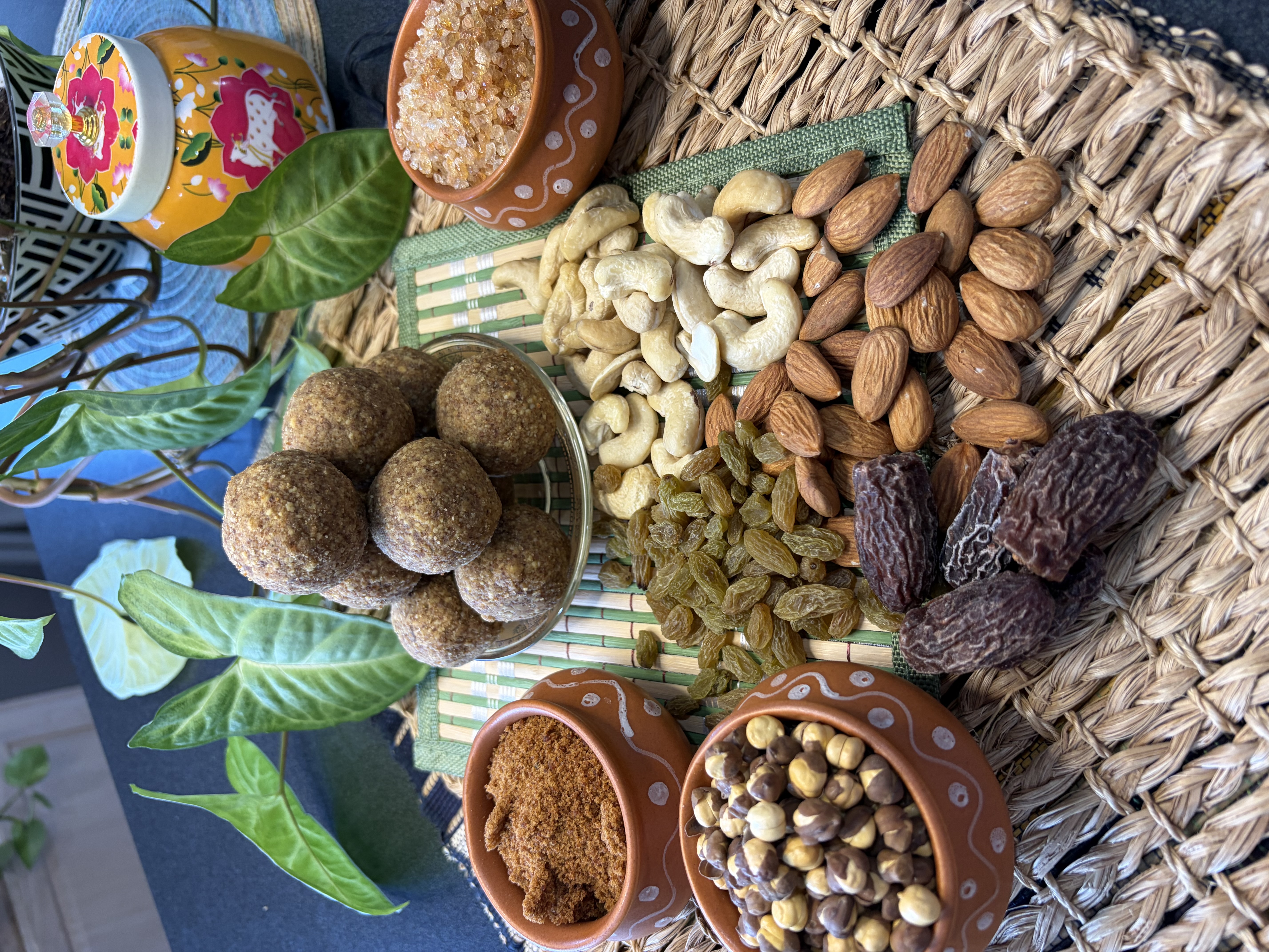 Handmade sattu gond laddoos surrounded by dates, almonds, cashews, raisins and jaggery